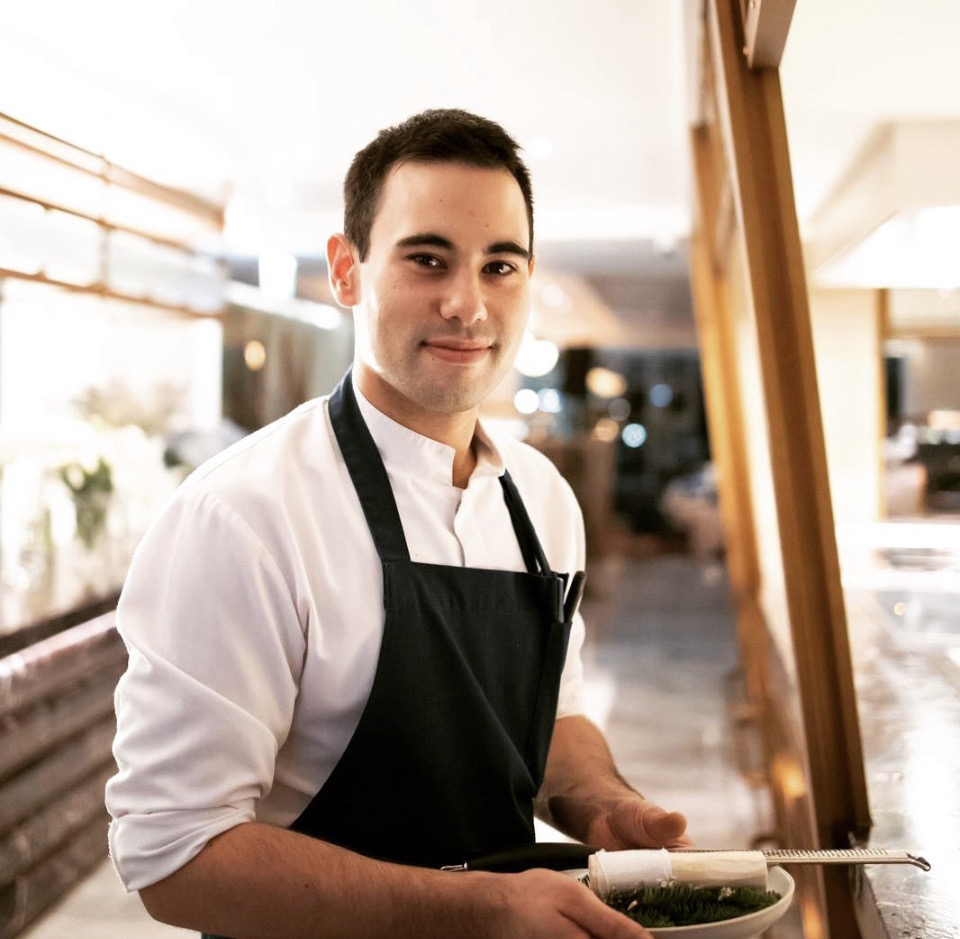 Nicholas Gannaway in the kitchen, holding a finished plate