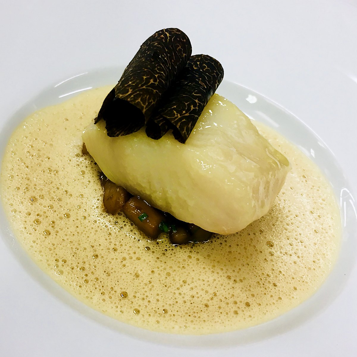 Poached fish with shaved black truffle and foam